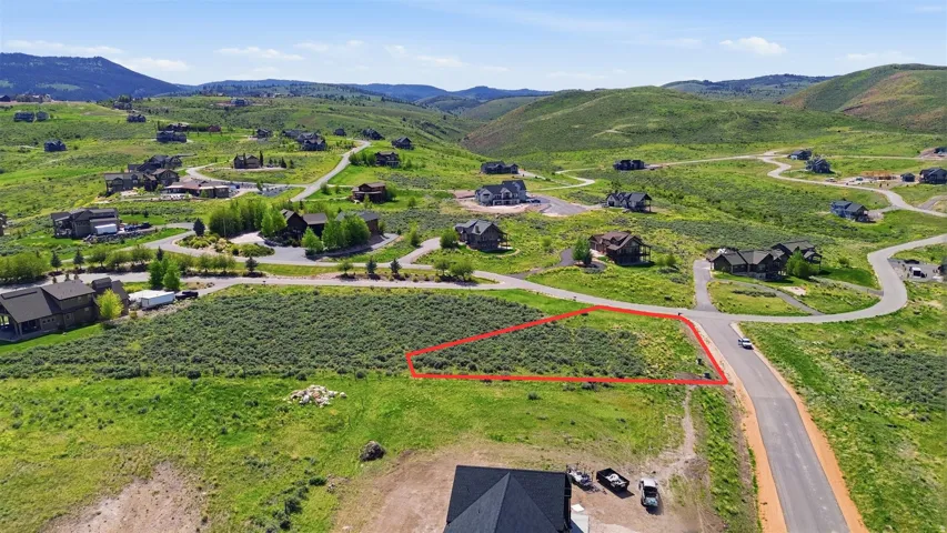 Expansive land parcel featuring natural terrain and a paved road