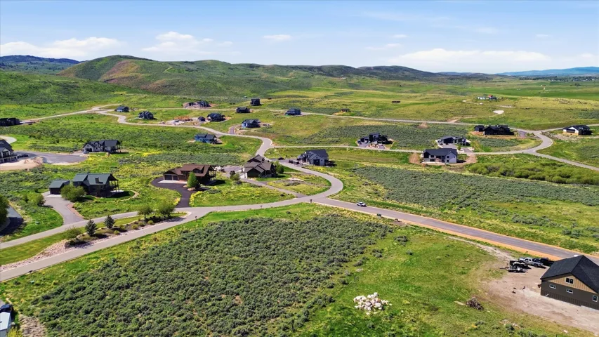 Expansive landscape featuring rolling green hills and scattered residential properties