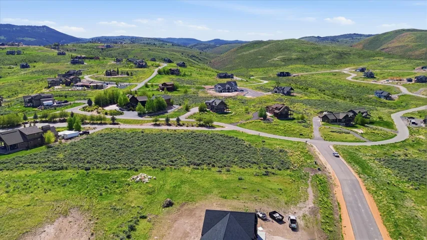 Expansive hillside properties with paved roadways winding through a green landscape