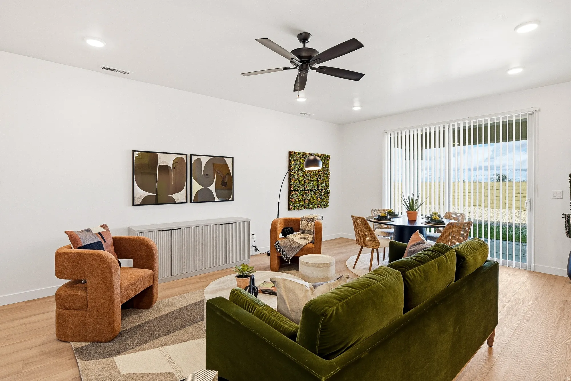 Living room featuring light wood finished floors, ceiling fan, and recessed lighting