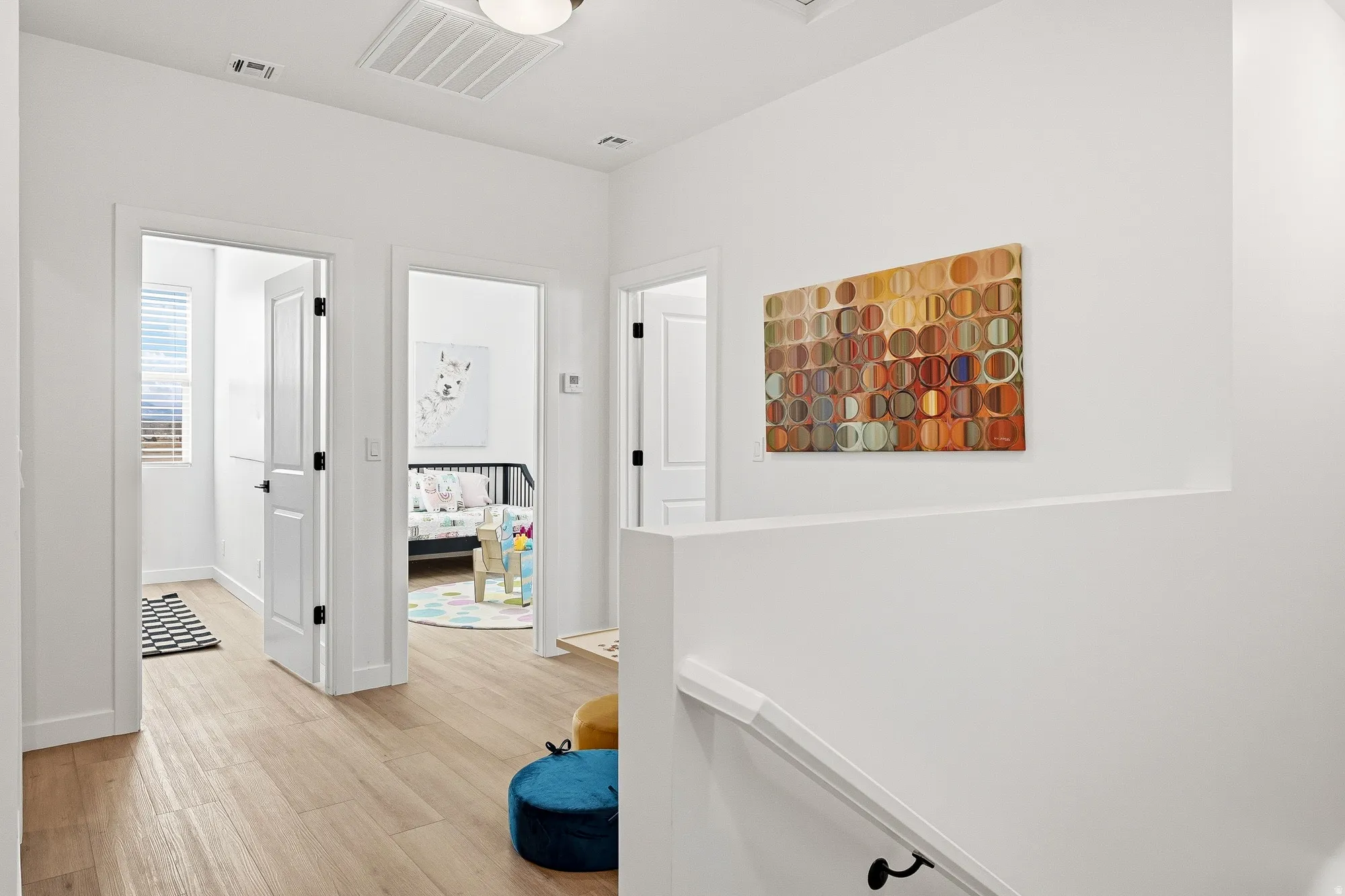 Corridor with light wood finished floors and an upstairs landing