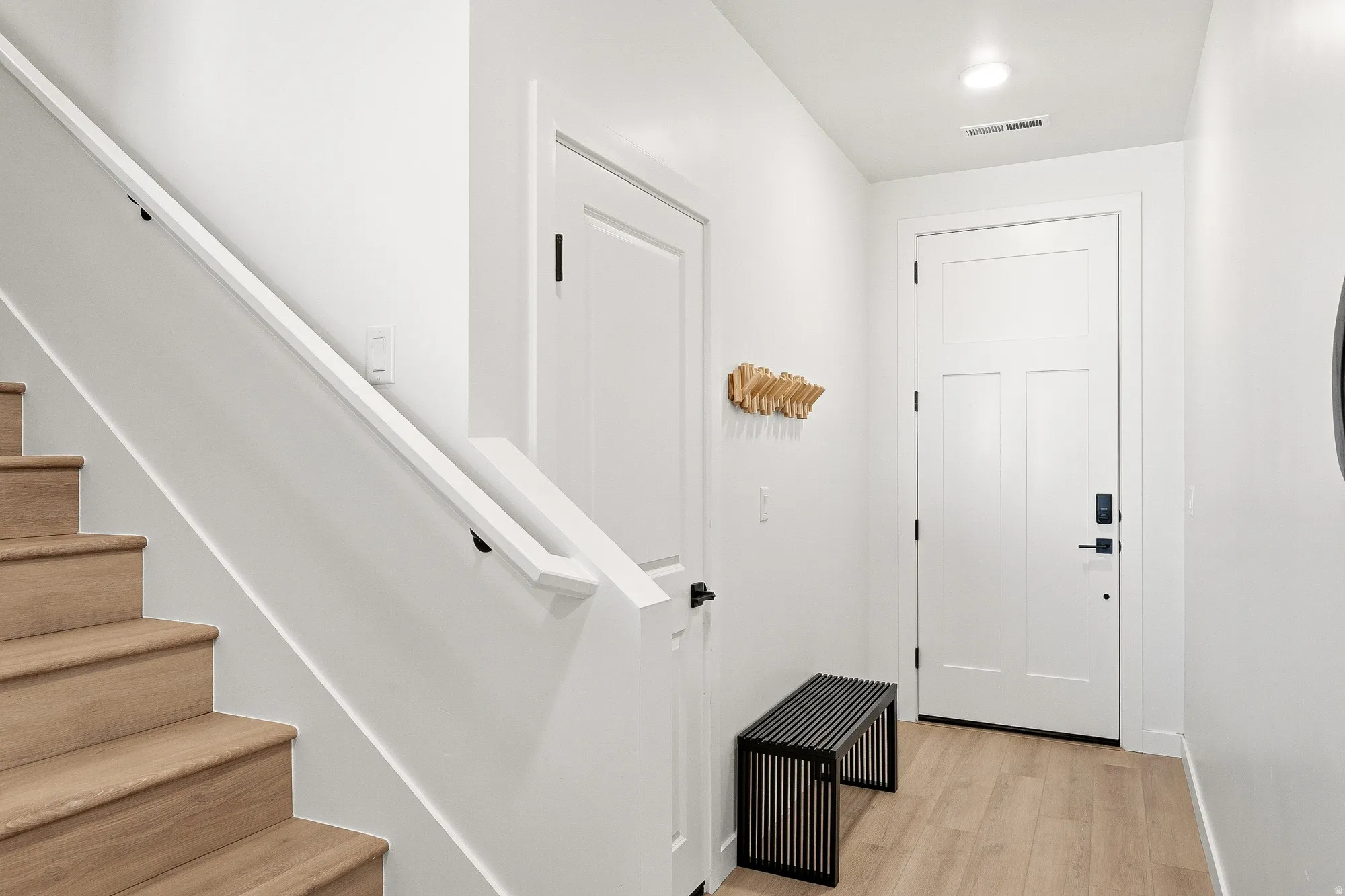 Doorway featuring stairway and wood finished floors