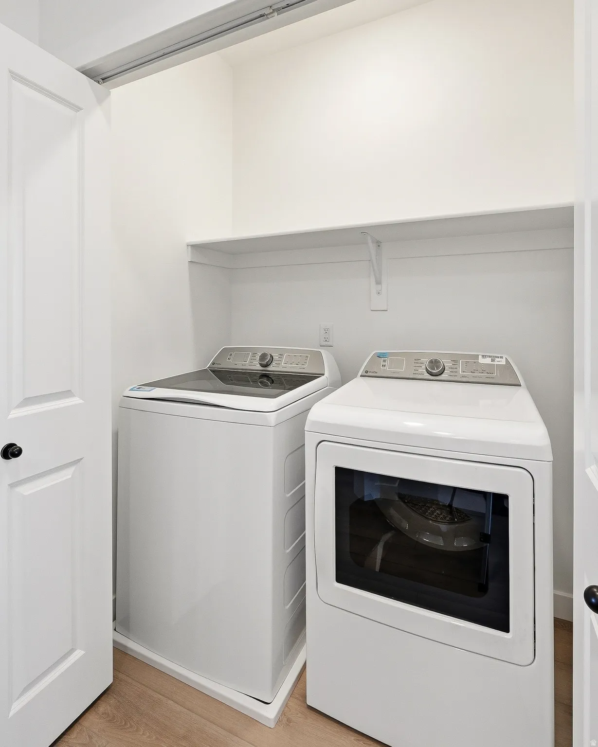 Laundry area with light wood finished floors and washer and dryer