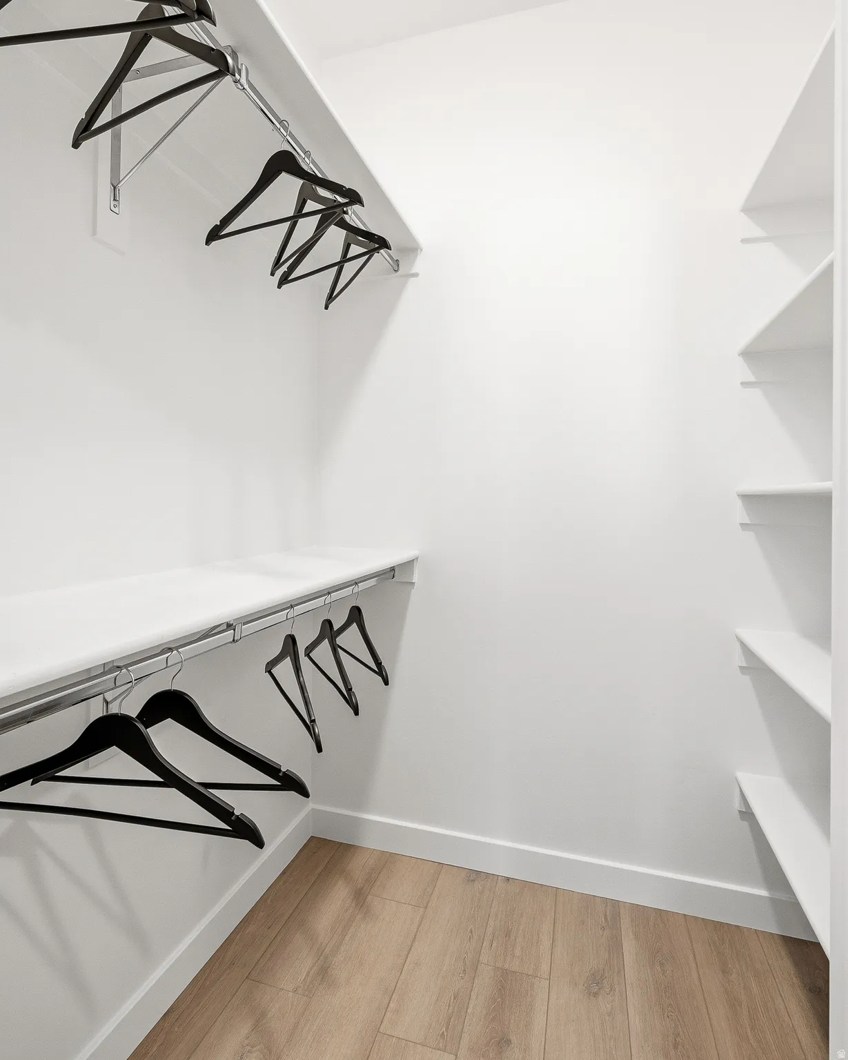 Walk in closet with light wood-style floors