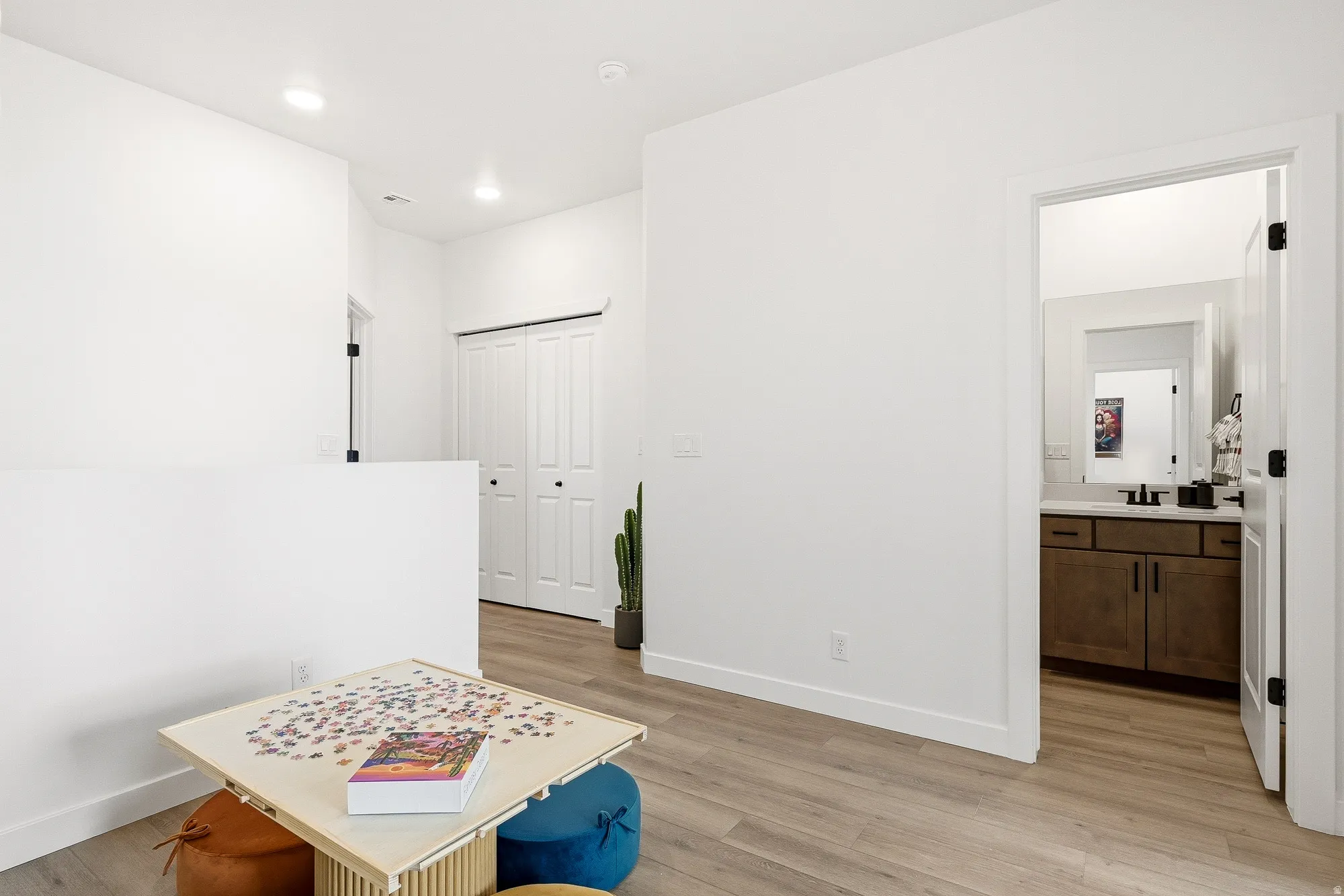 Hallway with light wood-type flooring and recessed lighting