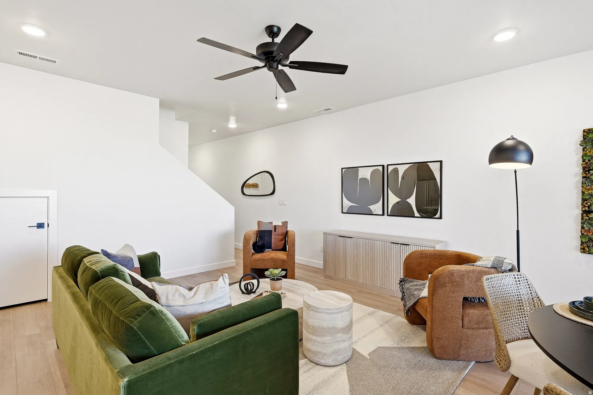 Living area with recessed lighting, a ceiling fan, and light wood-style floors