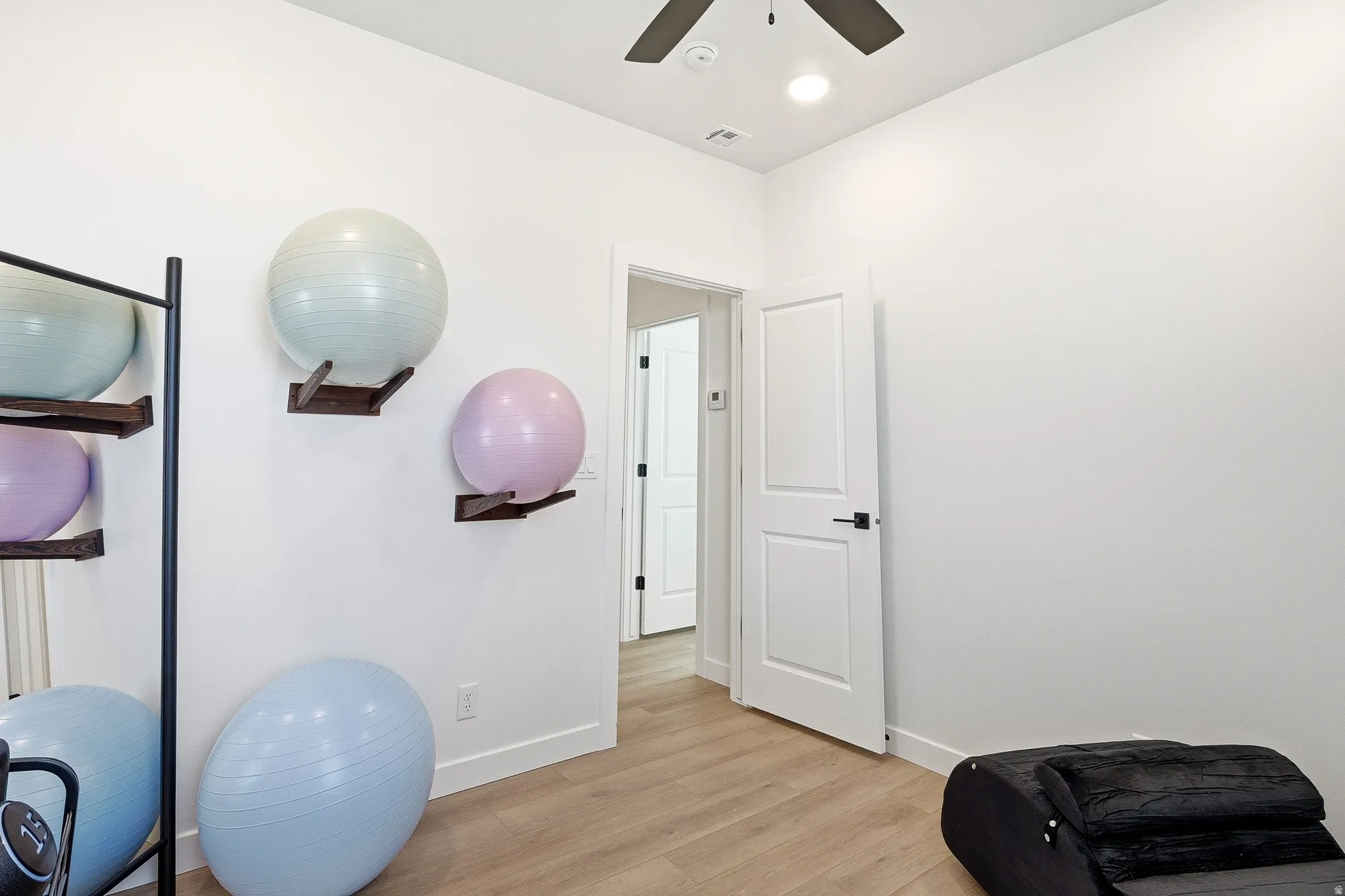 Workout room with light wood-type flooring, ceiling fan, and recessed lighting