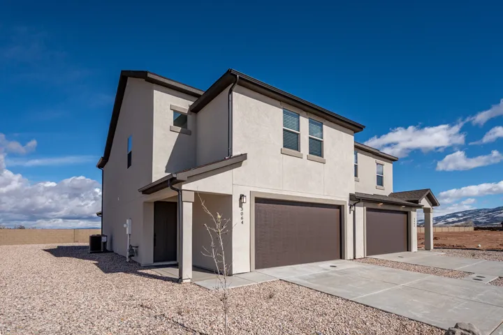 View of front of property featuring an attached garage, stucco siding, driveway, and a mountain view