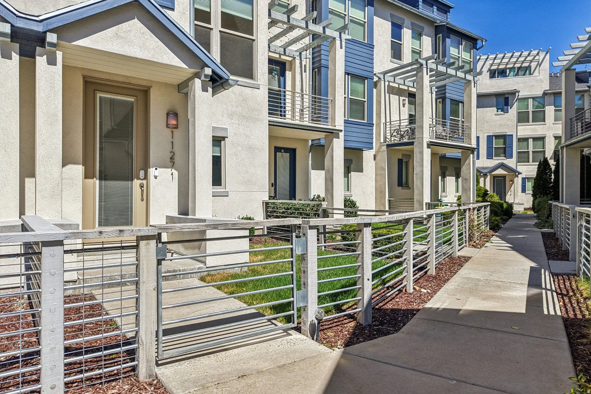 Exterior space with stucco siding, a gate, and a residential view