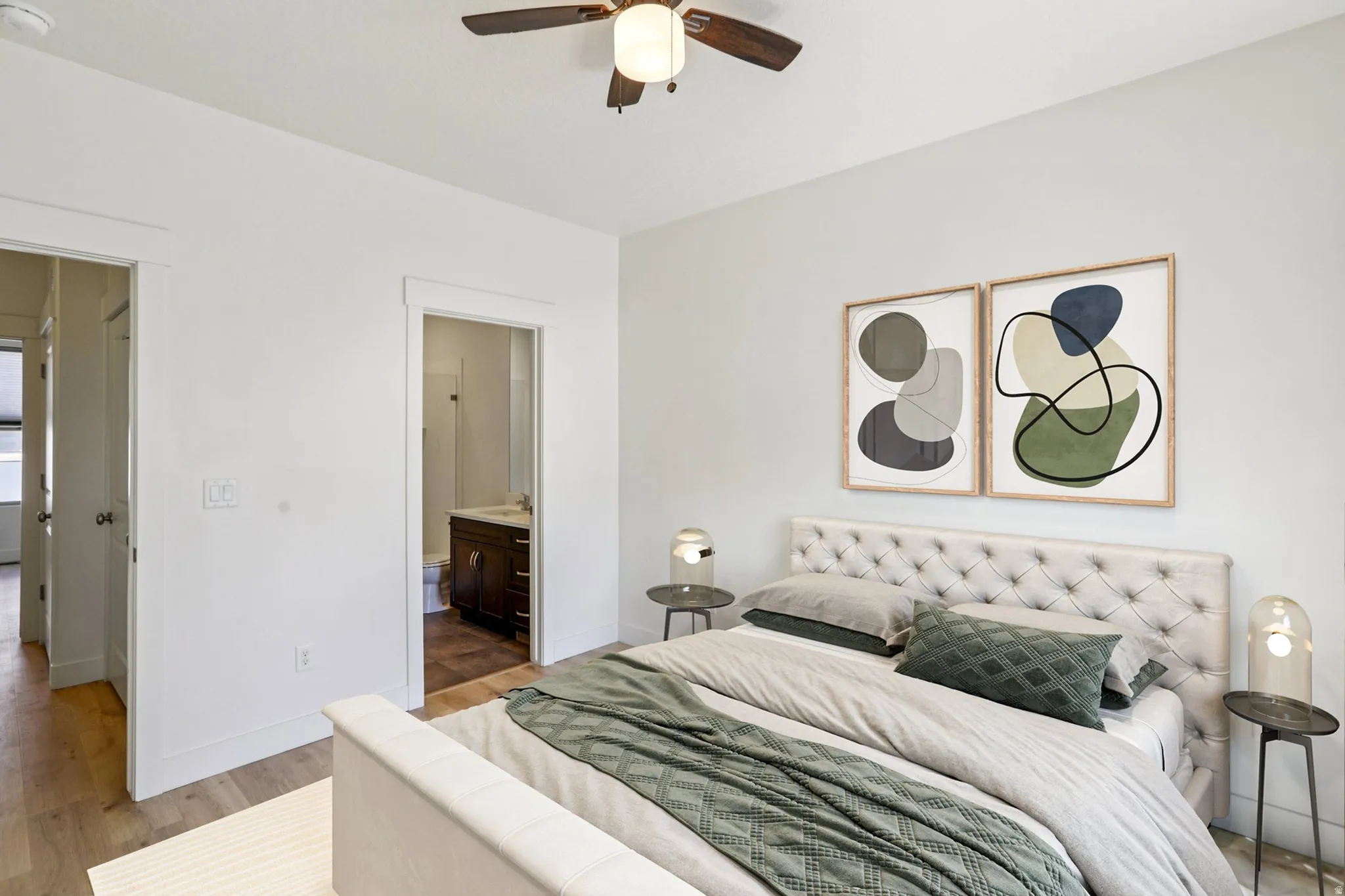 Bedroom with connected bathroom, light wood-type flooring, and ceiling fan