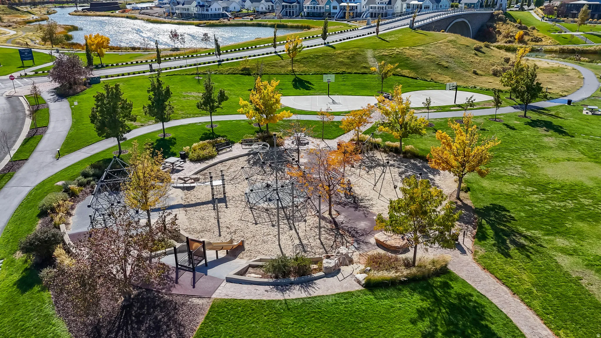 Aerial perspective of suburban area with a large body of water and a recreational park