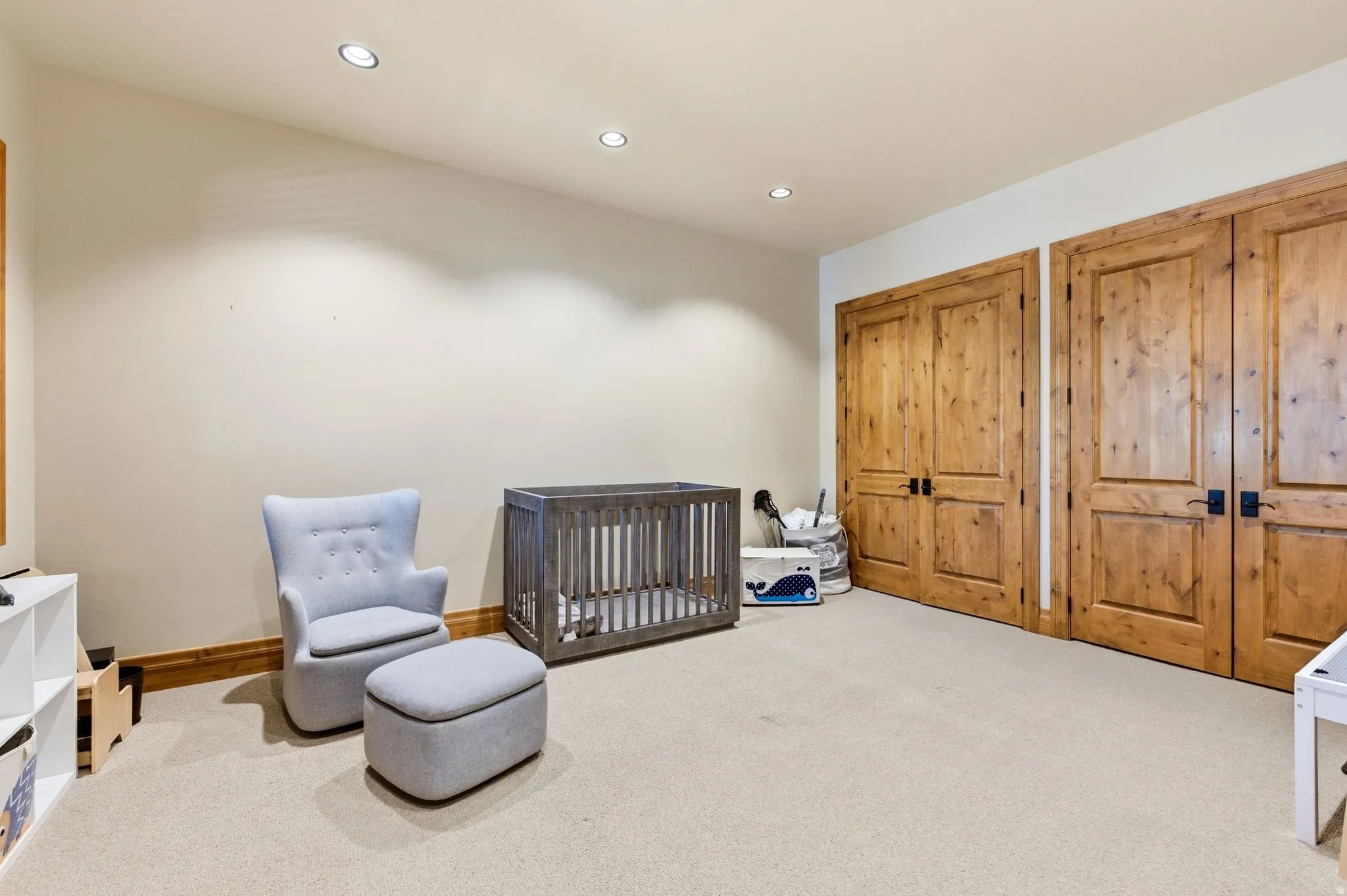 Carpeted bedroom with a nursery area, recessed lighting, and two closets