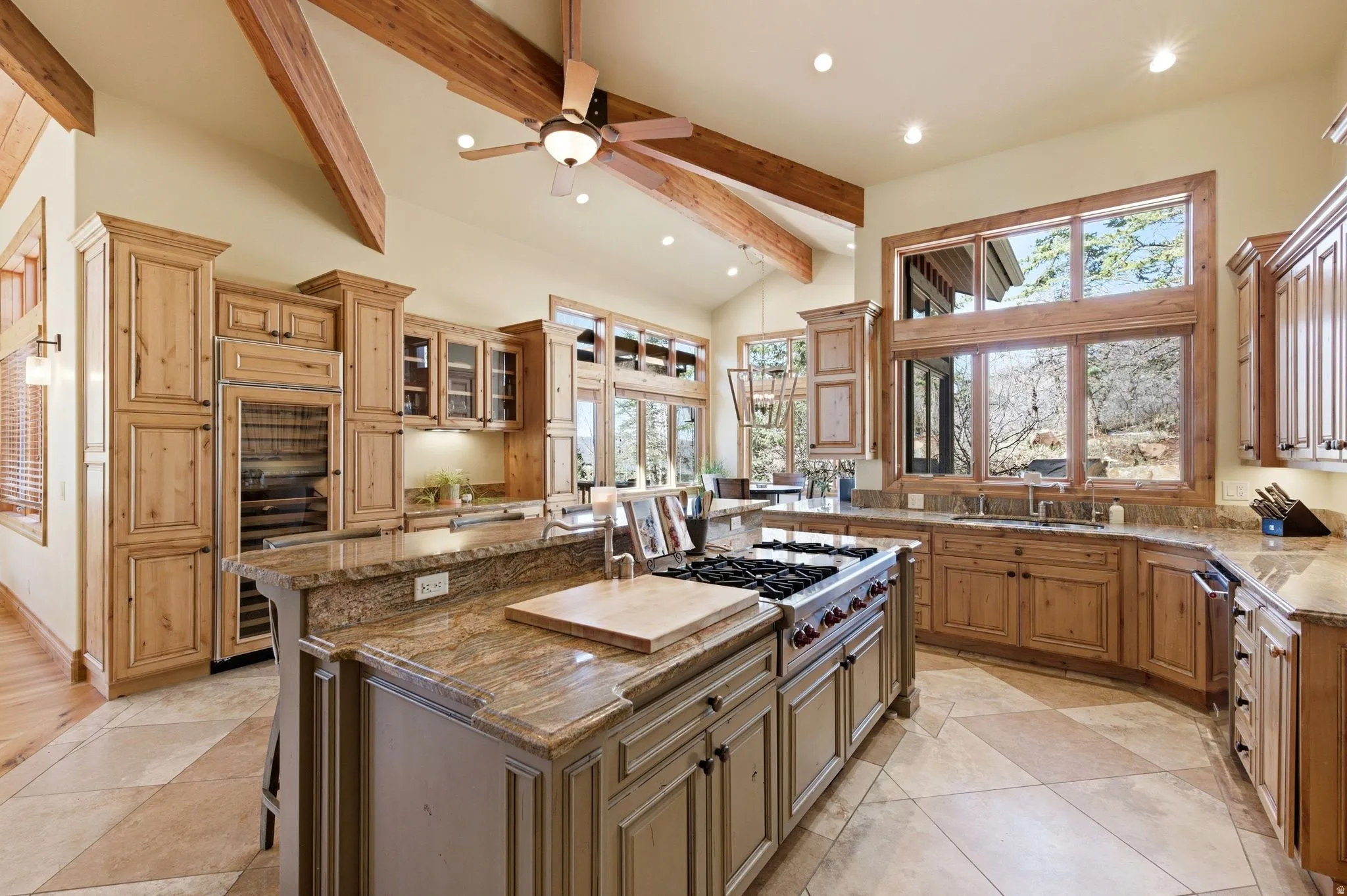 Kitchen with beverage cooler, a breakfast bar area, ceiling fan, vaulted ceiling, and a center island