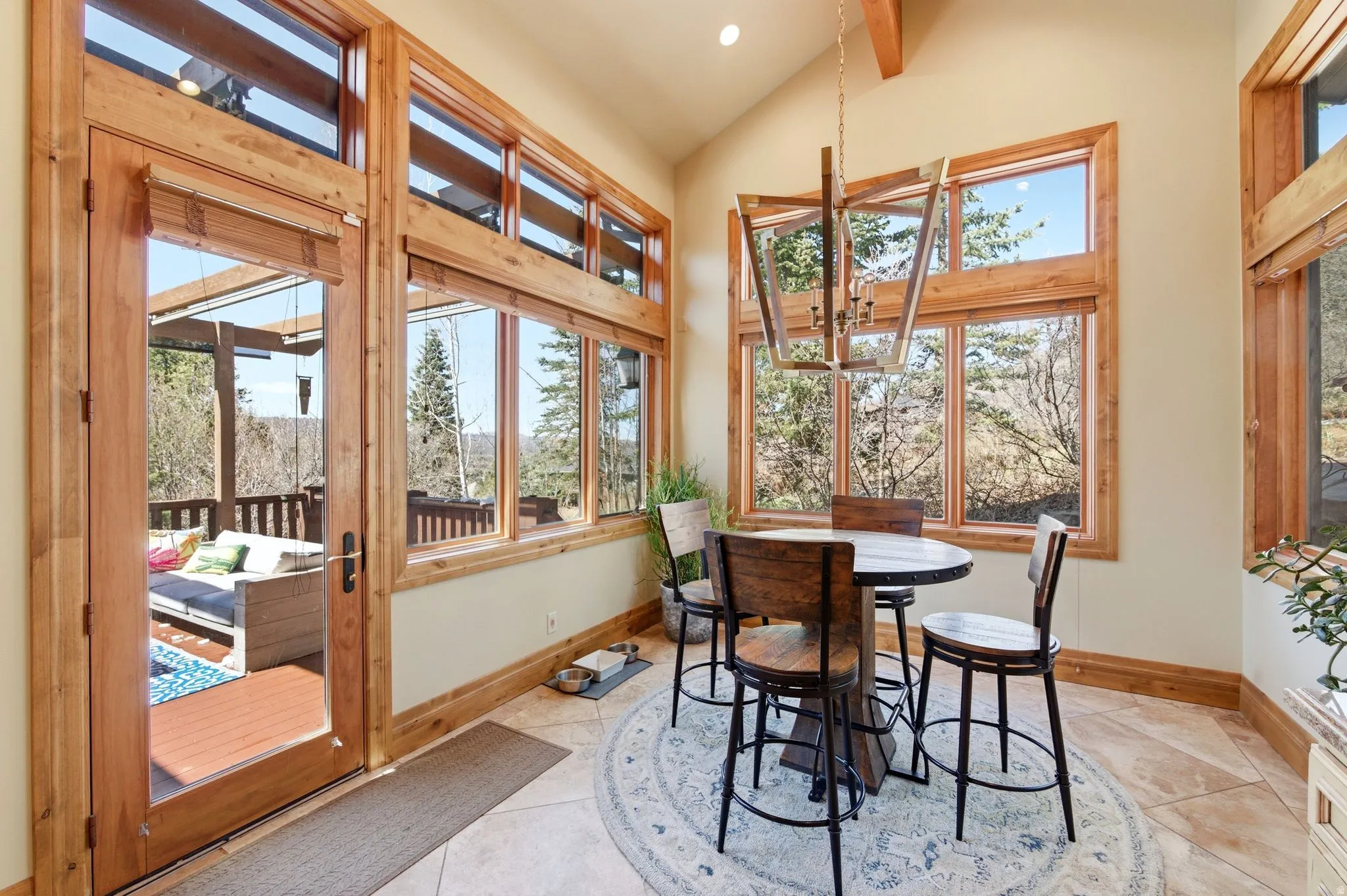 Sunroom / solarium with suspended lighting and vaulted ceiling with beams