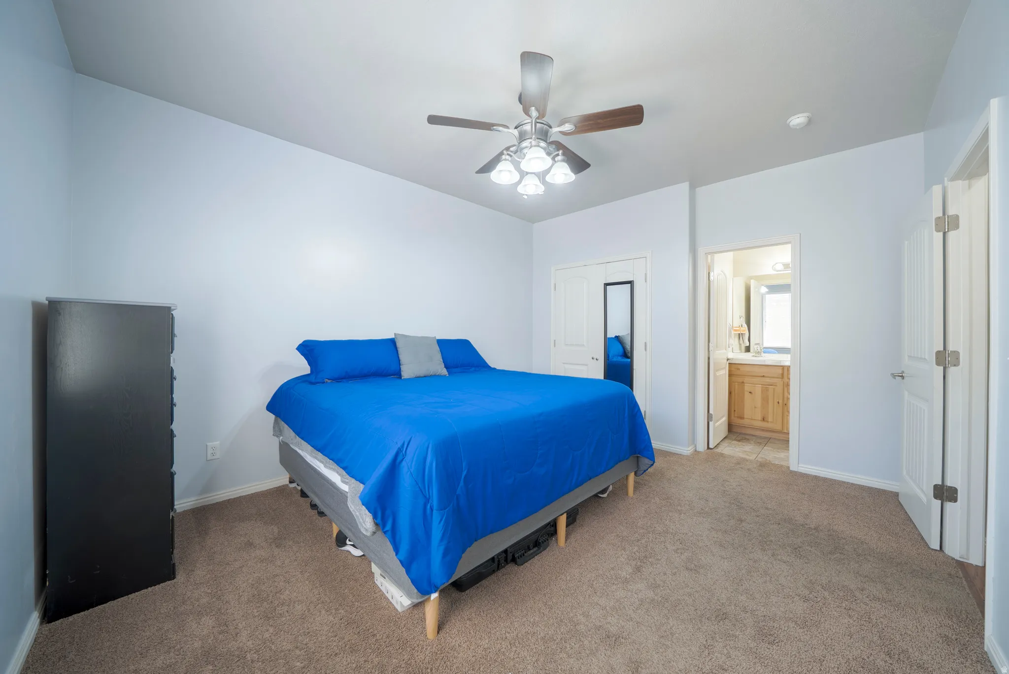 Carpeted bedroom featuring a ceiling fan and a closet