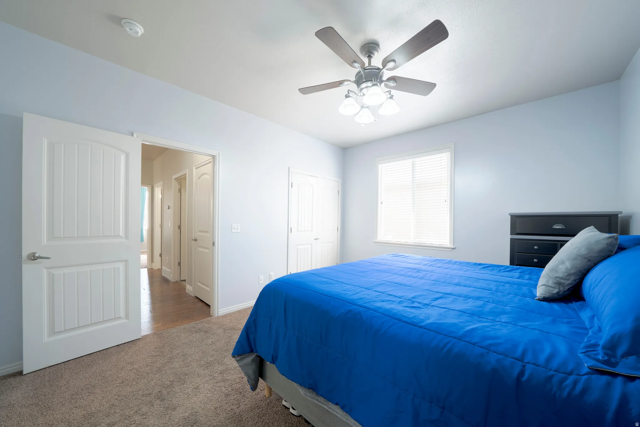 Bedroom with carpet flooring, ceiling fan, and a closet