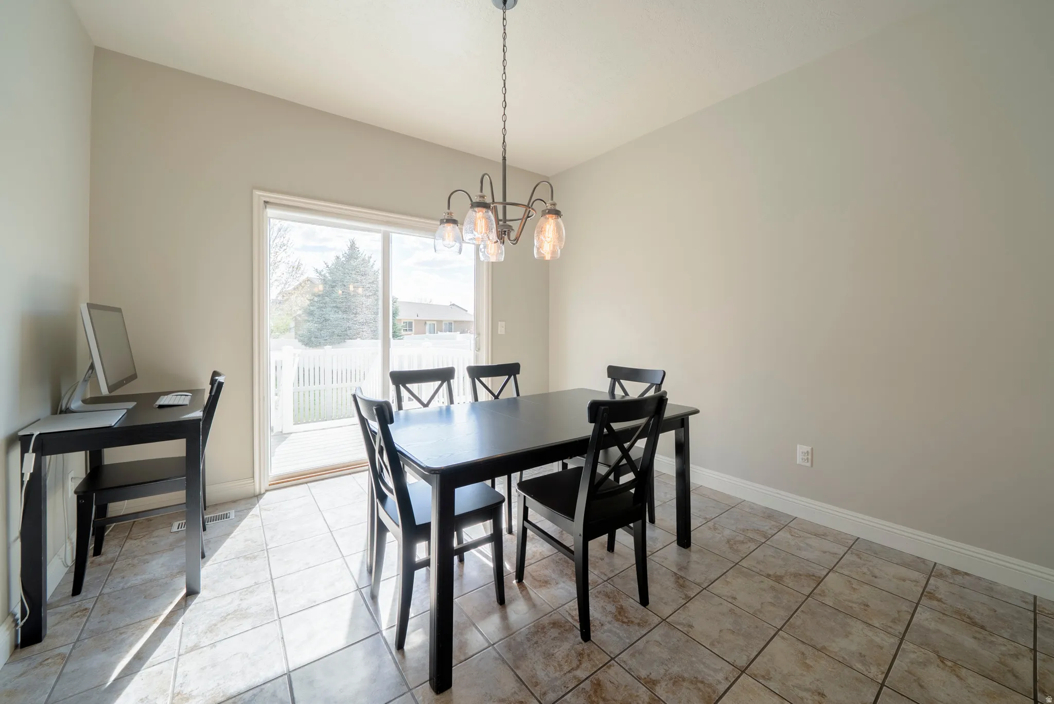Dining area featuring suspended lighting and light tile patterned flooring