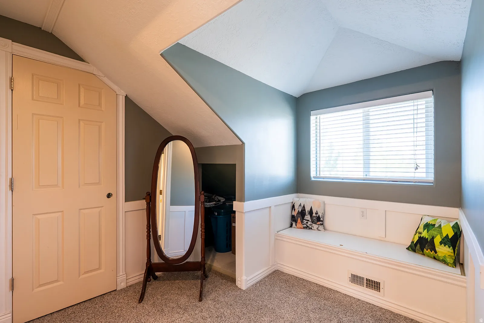 Bathroom with vaulted ceiling, carpet flooring, and a wainscoted wall