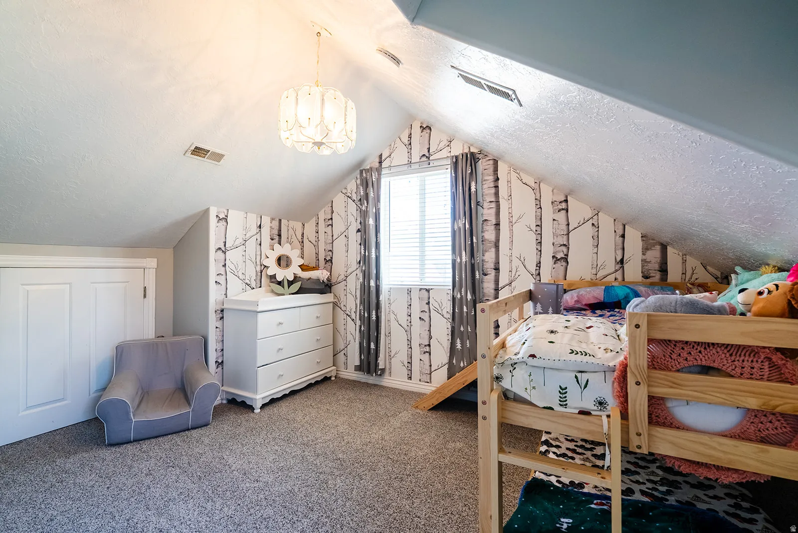 Bedroom featuring carpet floors, a chandelier, a textured ceiling, wallpapered walls, and a closet