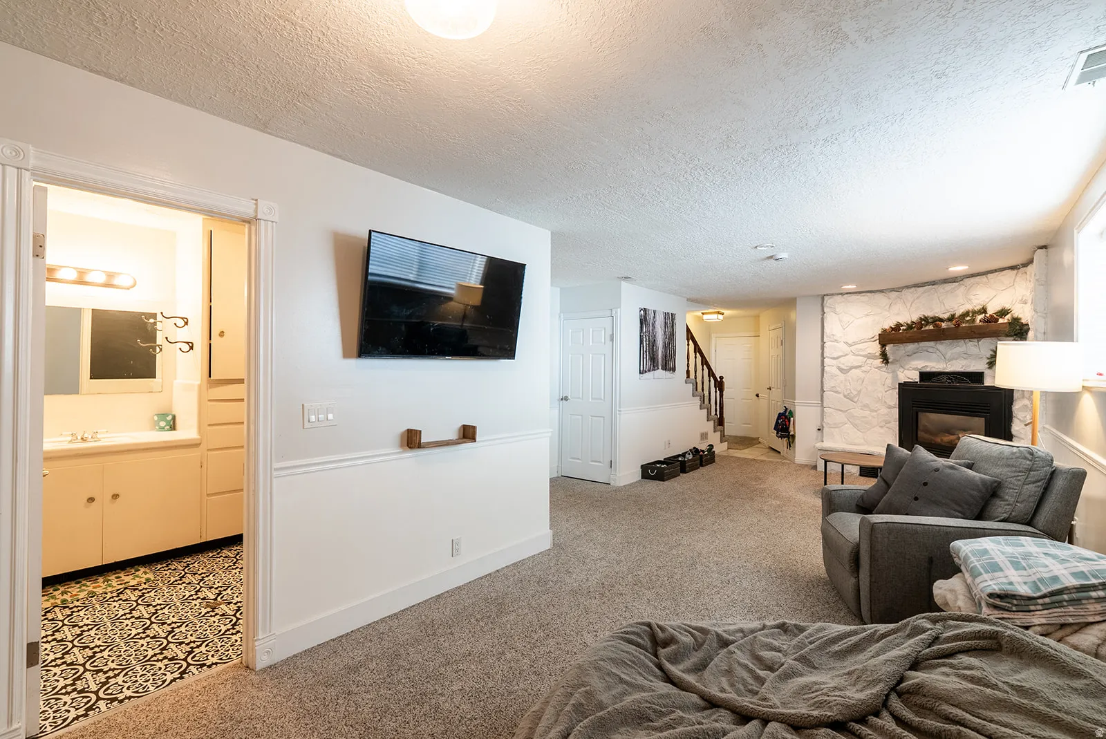 Living room with light carpet, a fireplace, and a textured ceiling