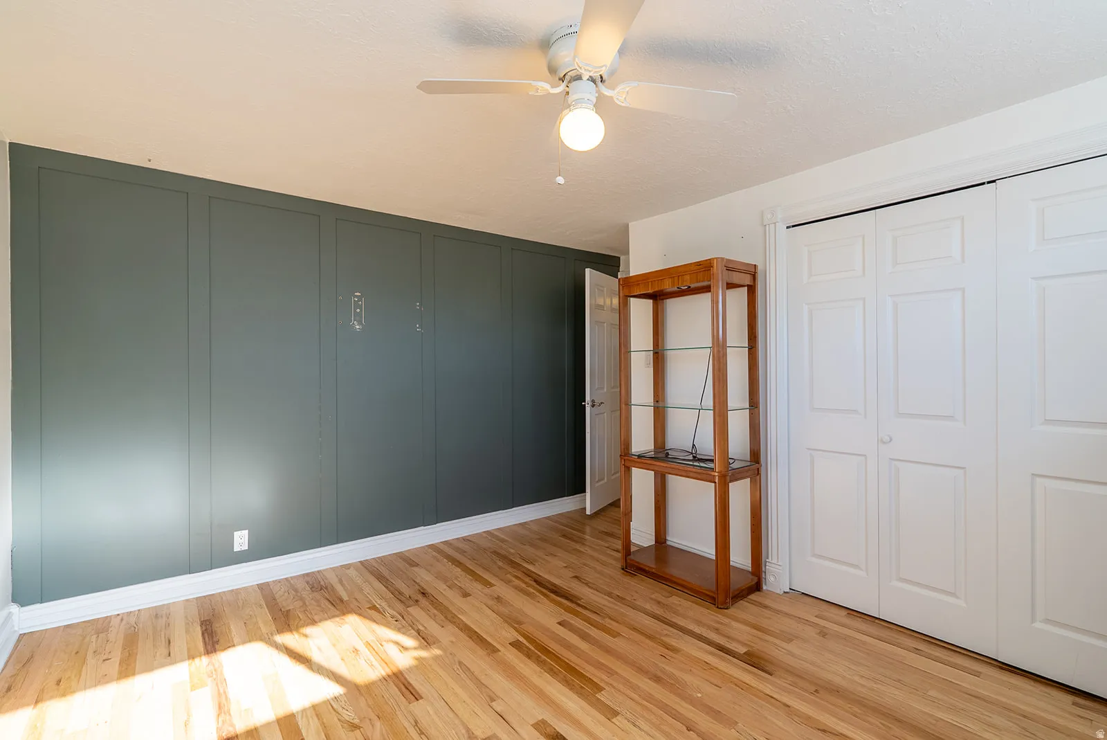 Unfurnished bedroom with light wood finished floors, a ceiling fan, and a closet
