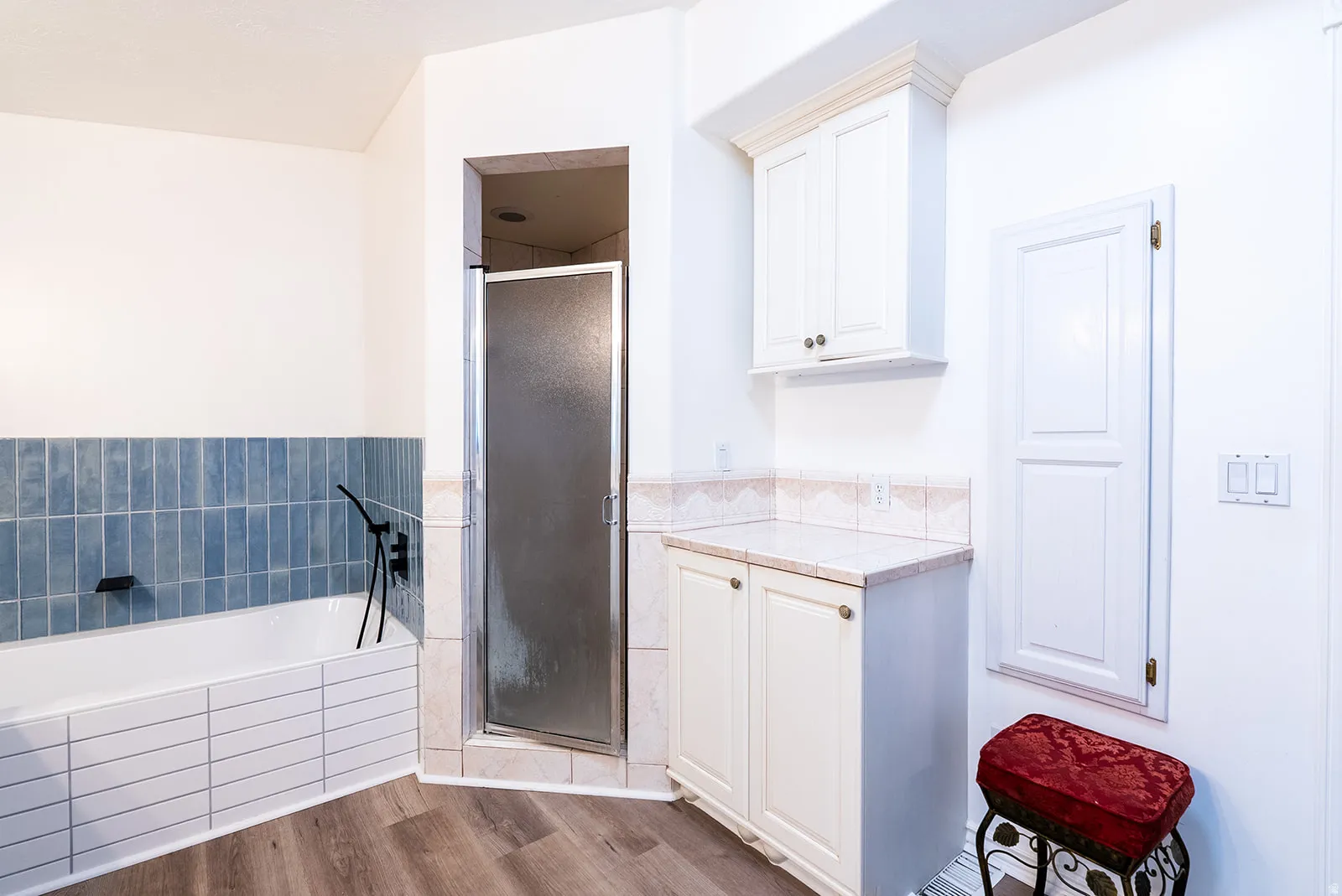 Bathroom featuring a shower stall, a bath, and dark wood-style flooring