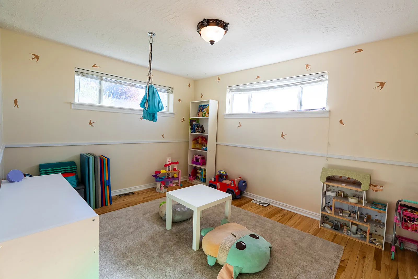 Playroom featuring light wood-style flooring and a textured ceiling
