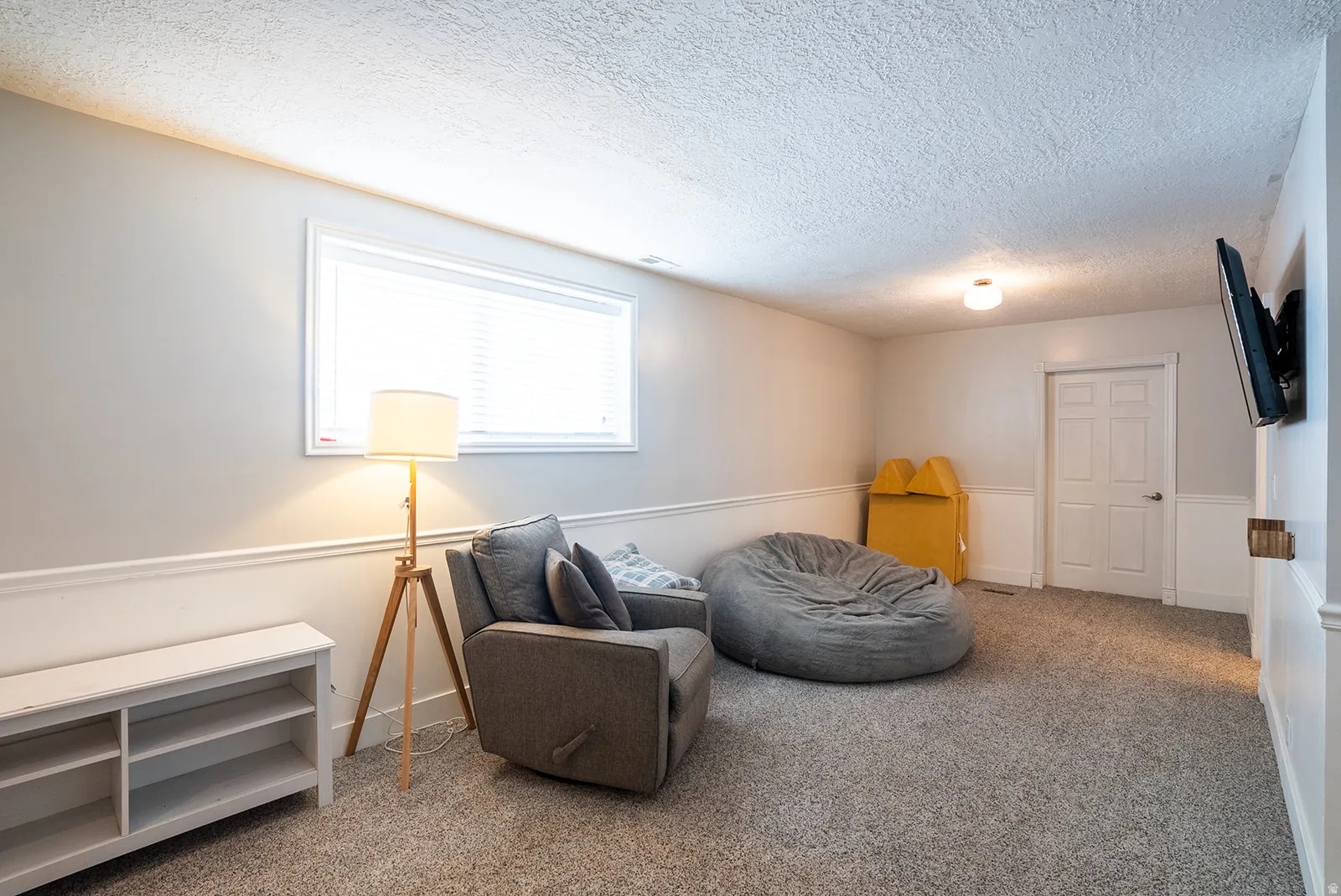Sitting room featuring carpet flooring and a textured ceiling