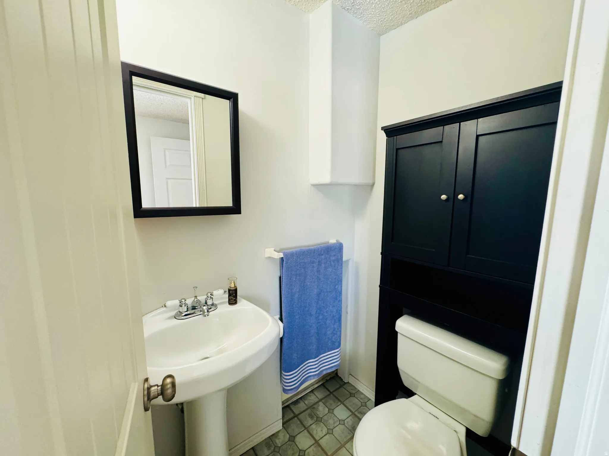 Half bathroom featuring a textured ceiling and tile patterned floors