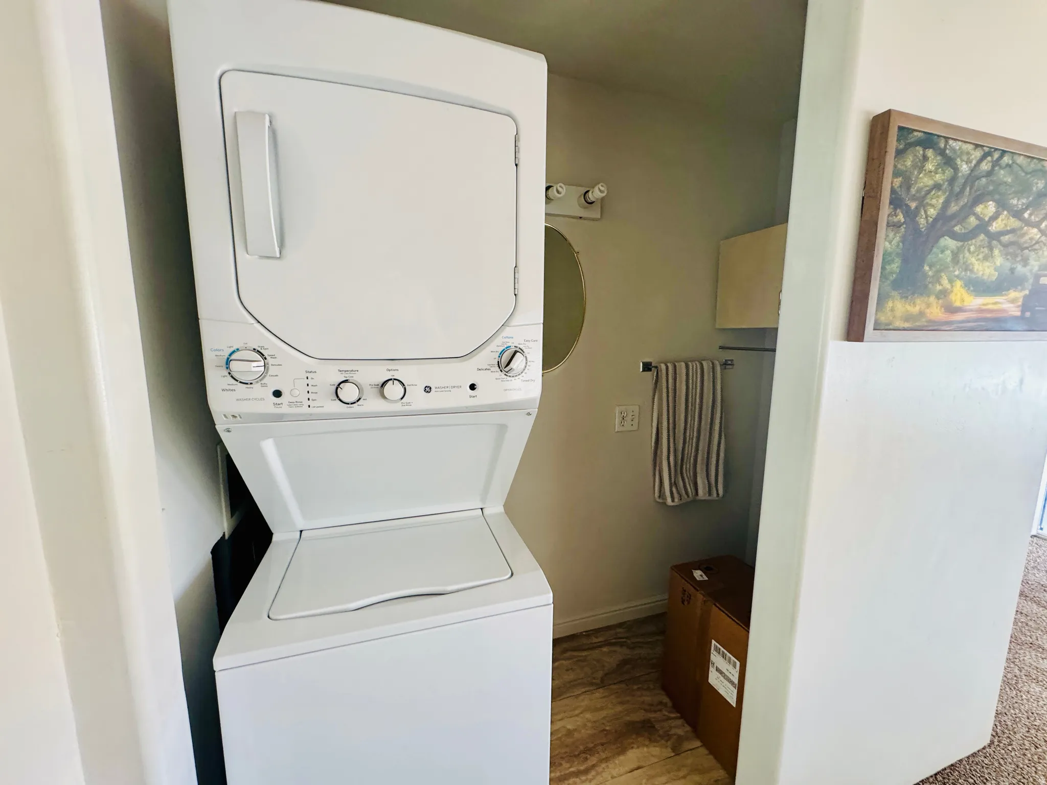 Laundry area featuring stacked washer and clothes dryer and wood finished floors