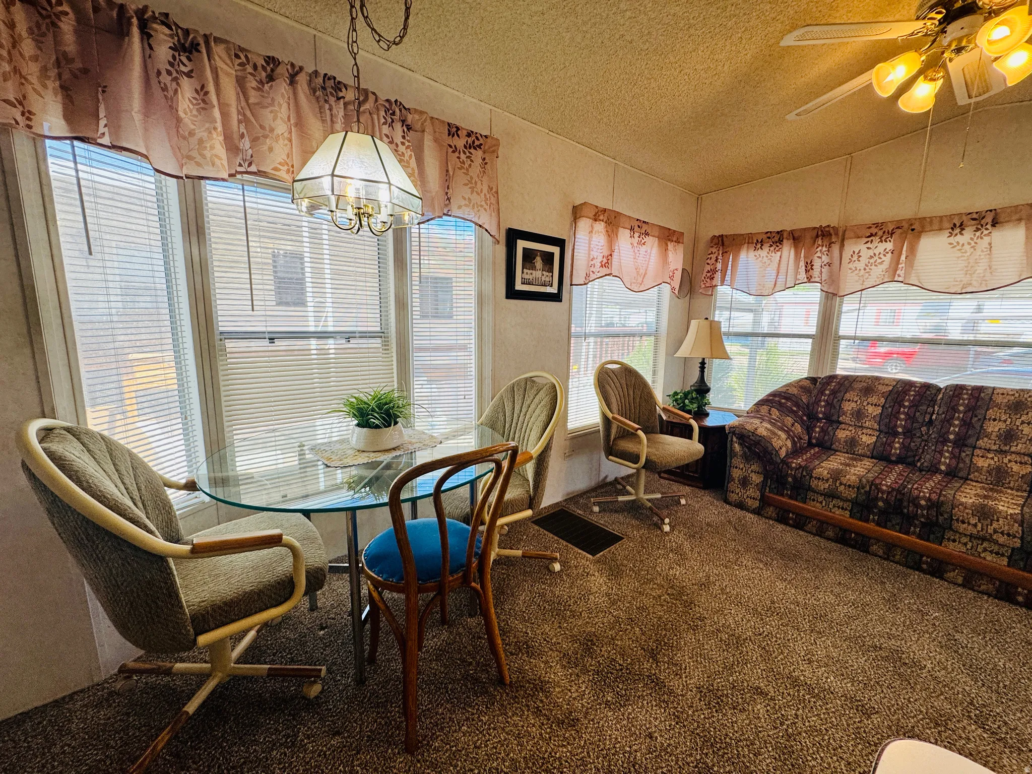 Carpeted dining space with a ceiling fan and hanging lights