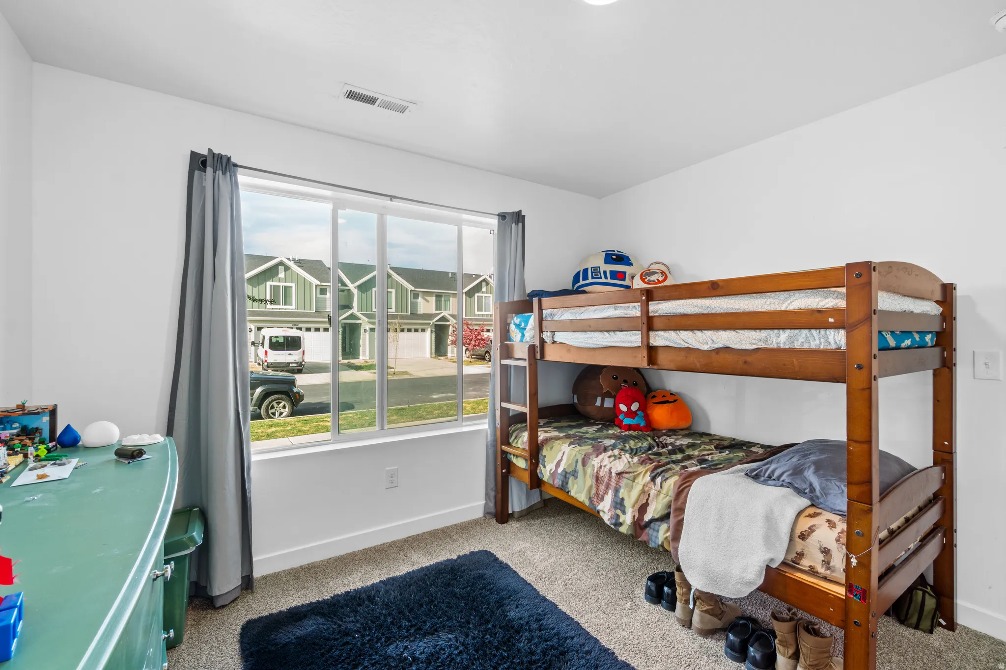 Bedroom with light carpet and a residential view
