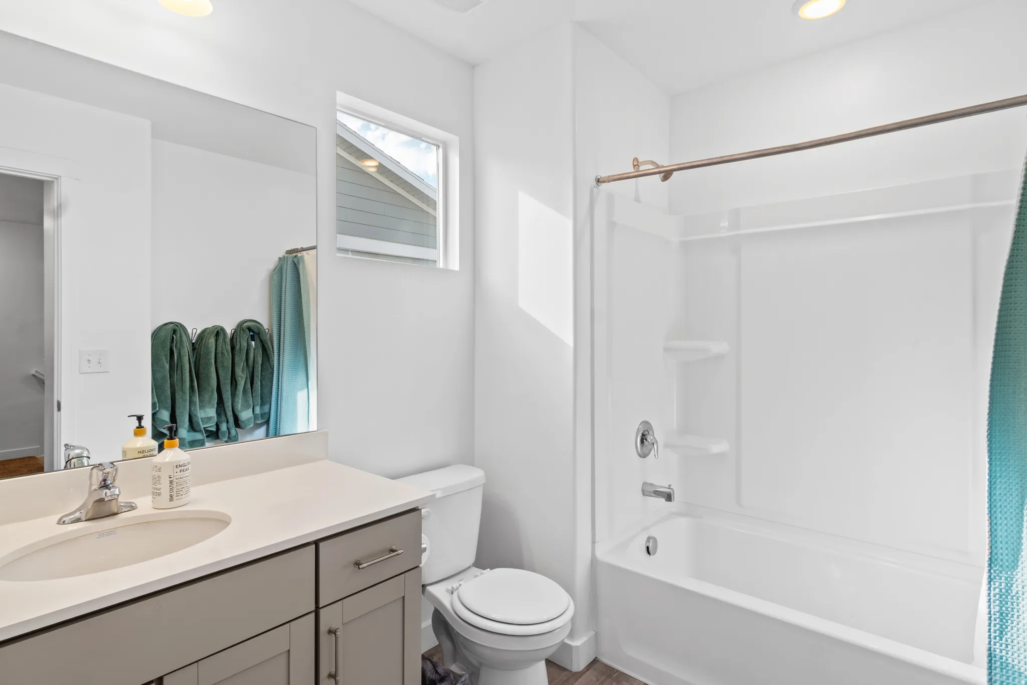 Bathroom featuring vanity, shower / tub combo with curtain, and recessed lighting