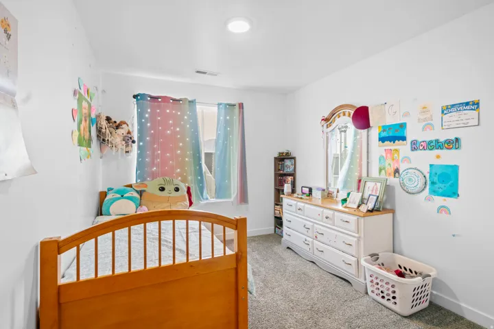 Bedroom with light colored carpet and baseboards