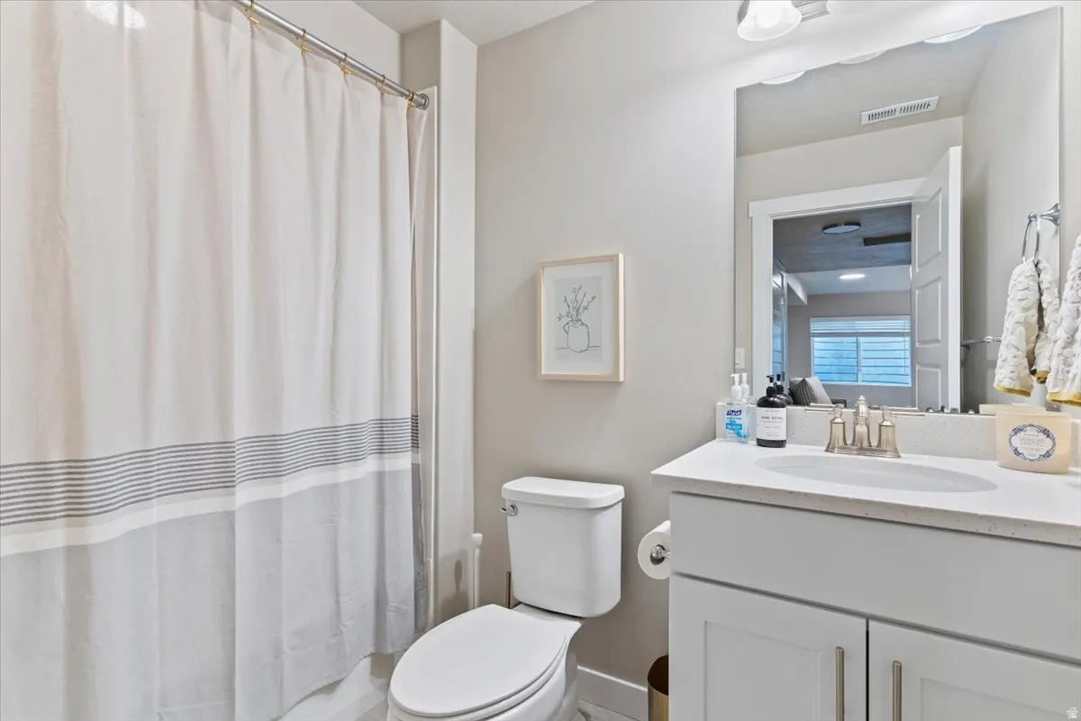 Bathroom featuring a shower with shower curtain and vanity