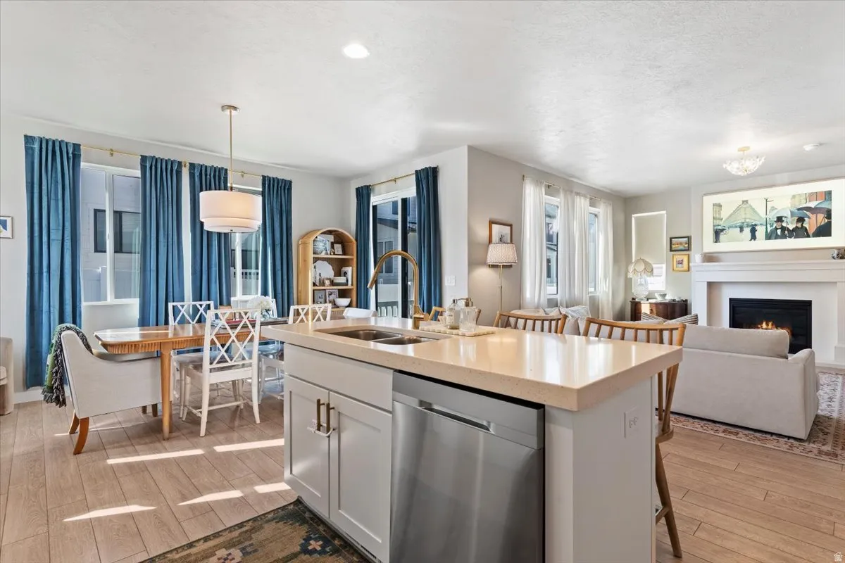 Kitchen with a breakfast bar area, dishwasher, and light wood-style floors