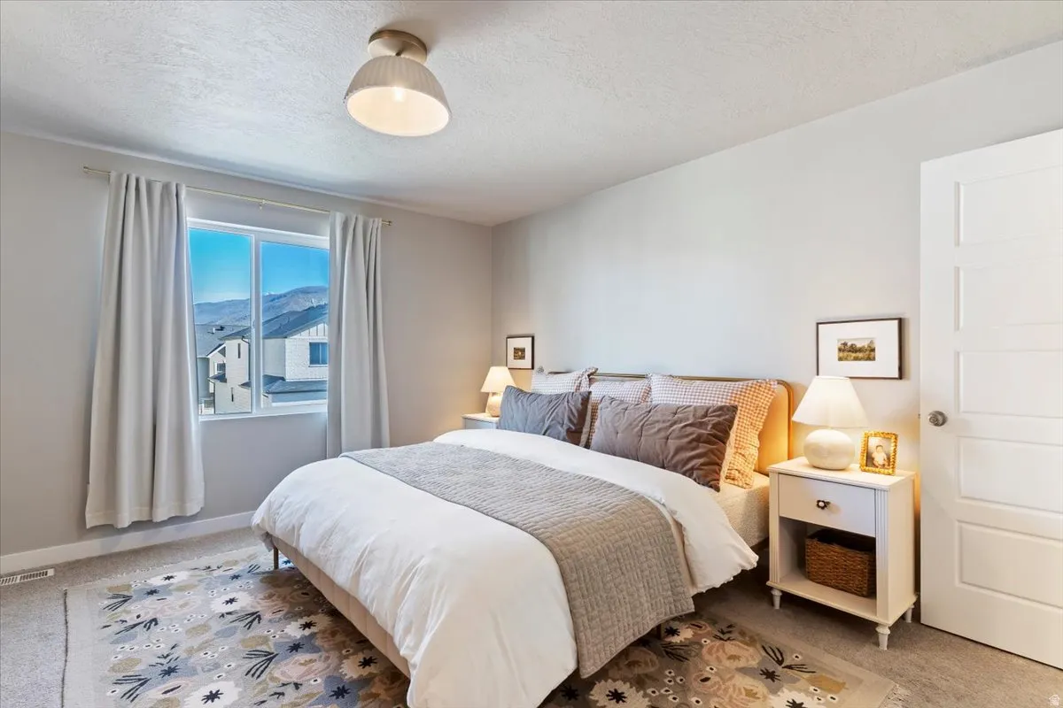 Carpeted bedroom featuring a mountain view and a textured ceiling