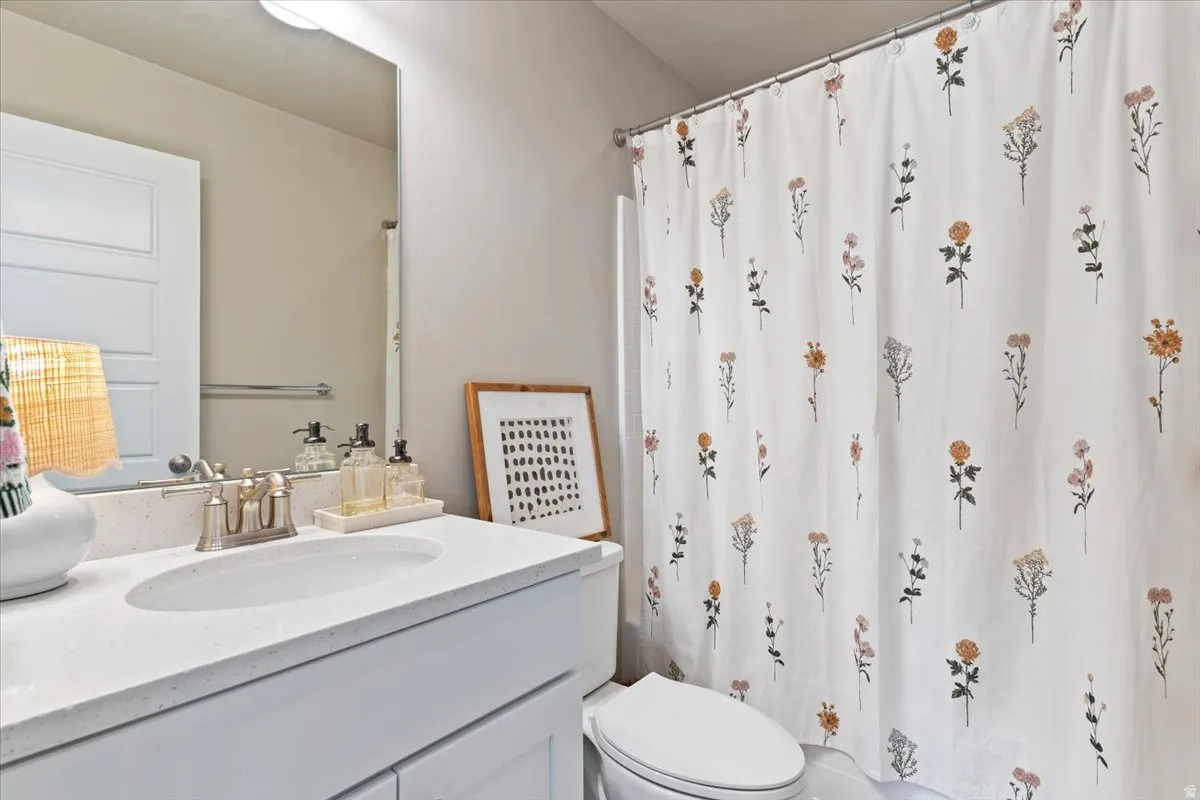 Full bath featuring vanity and curtained shower