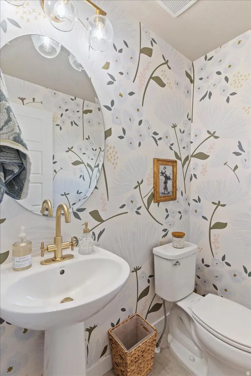 Bathroom with wallpapered walls and toilet