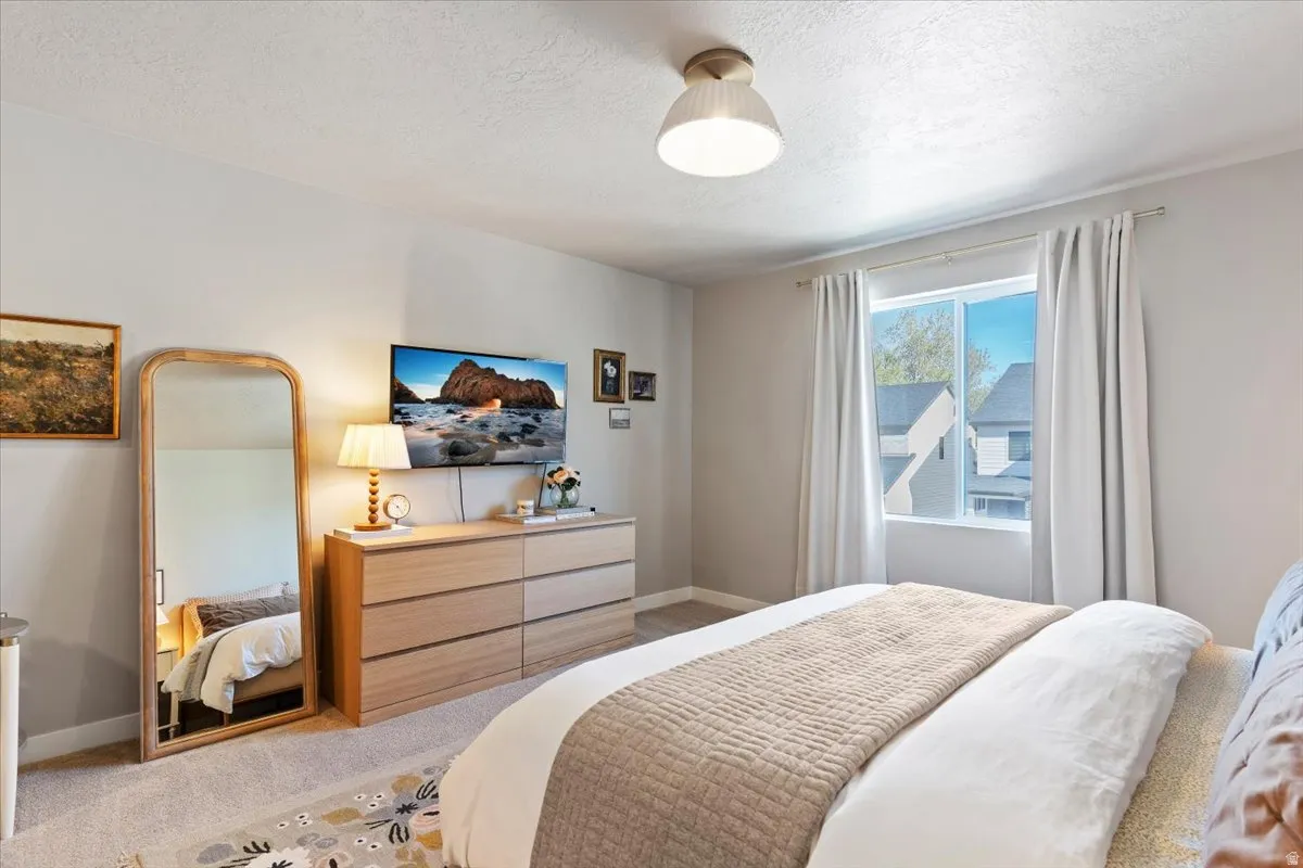 Bedroom with light carpet and a textured ceiling
