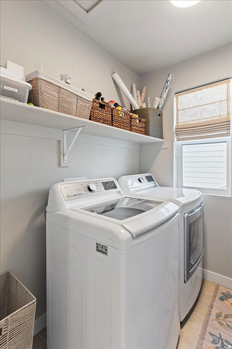 Laundry room with washing machine and clothes dryer and baseboards
