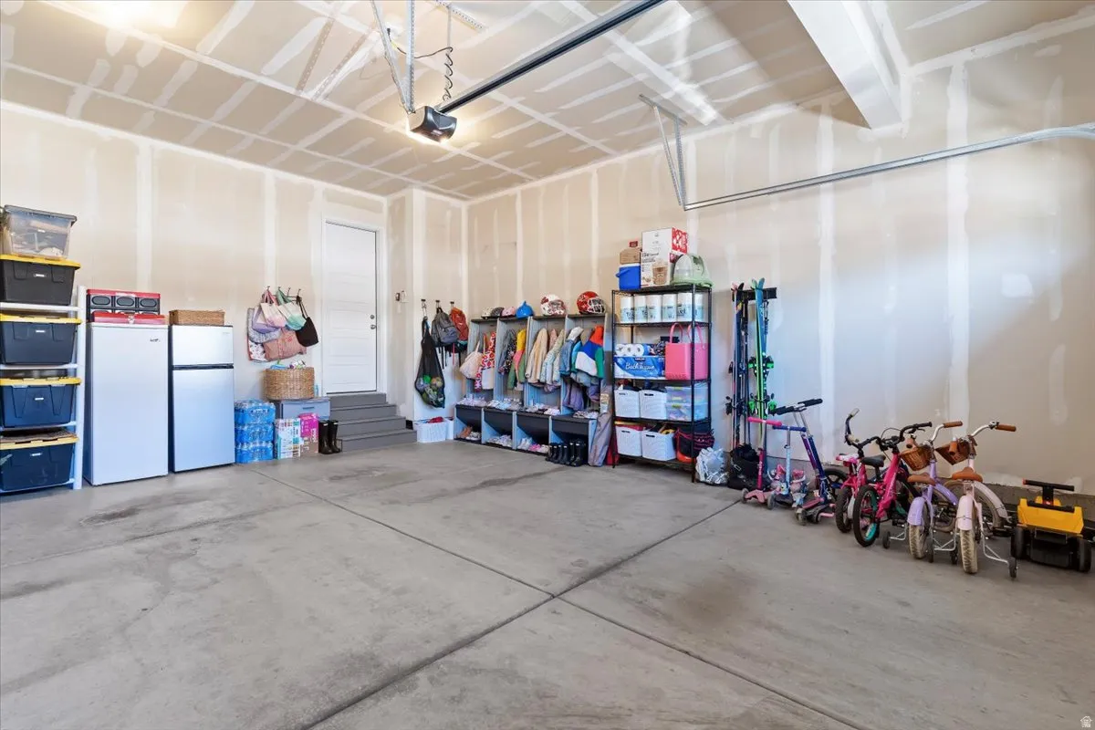 Garage with freestanding refrigerator and white fridge