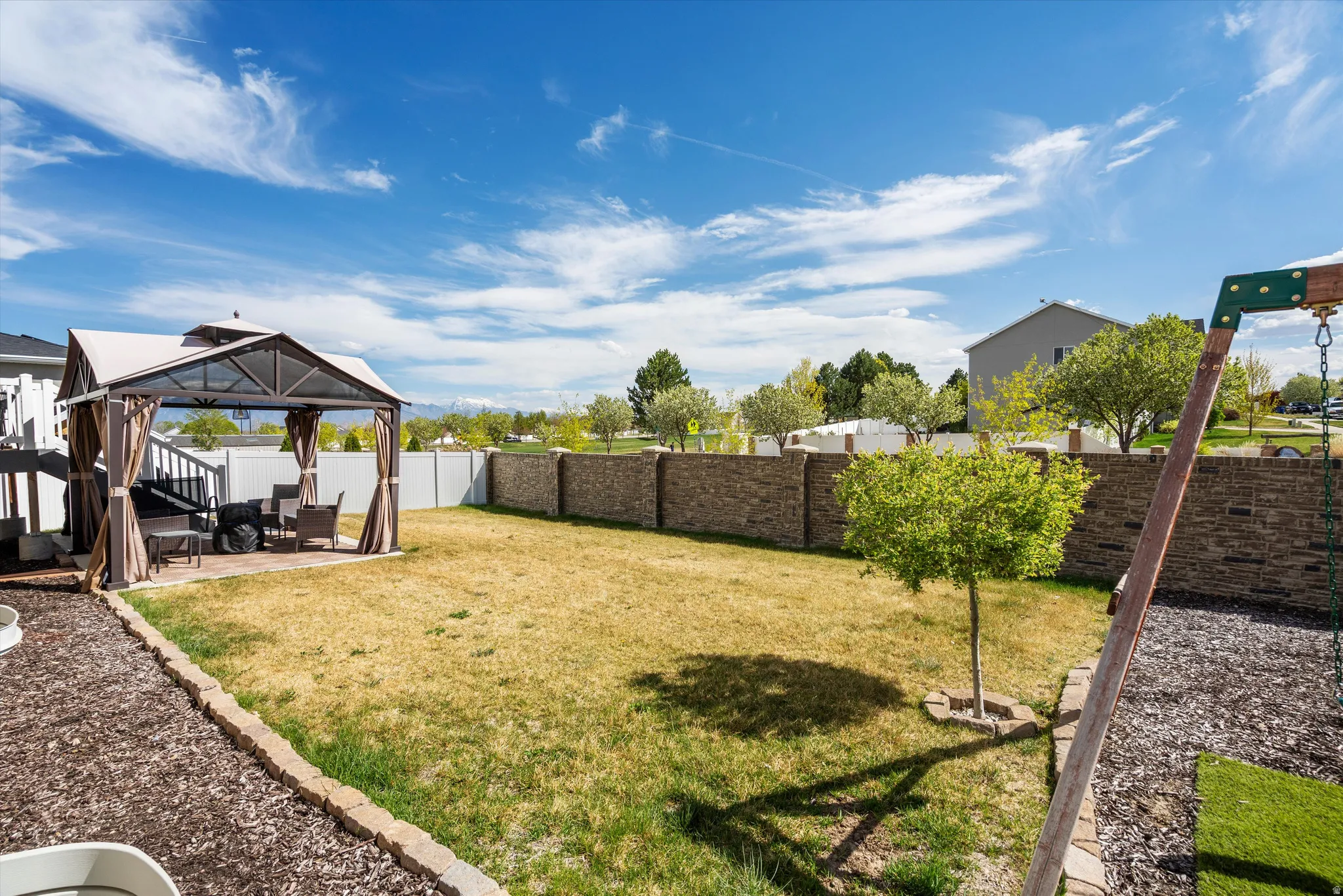 Fenced backyard with a gazebo and a patio