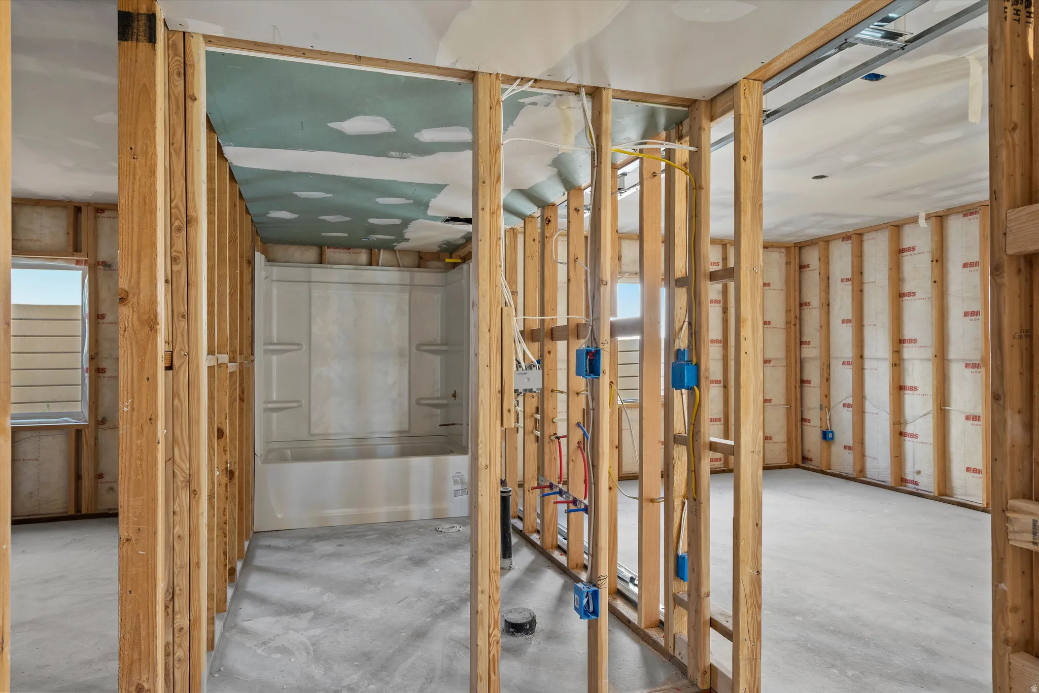 Bathroom with tub / shower combination and concrete flooring