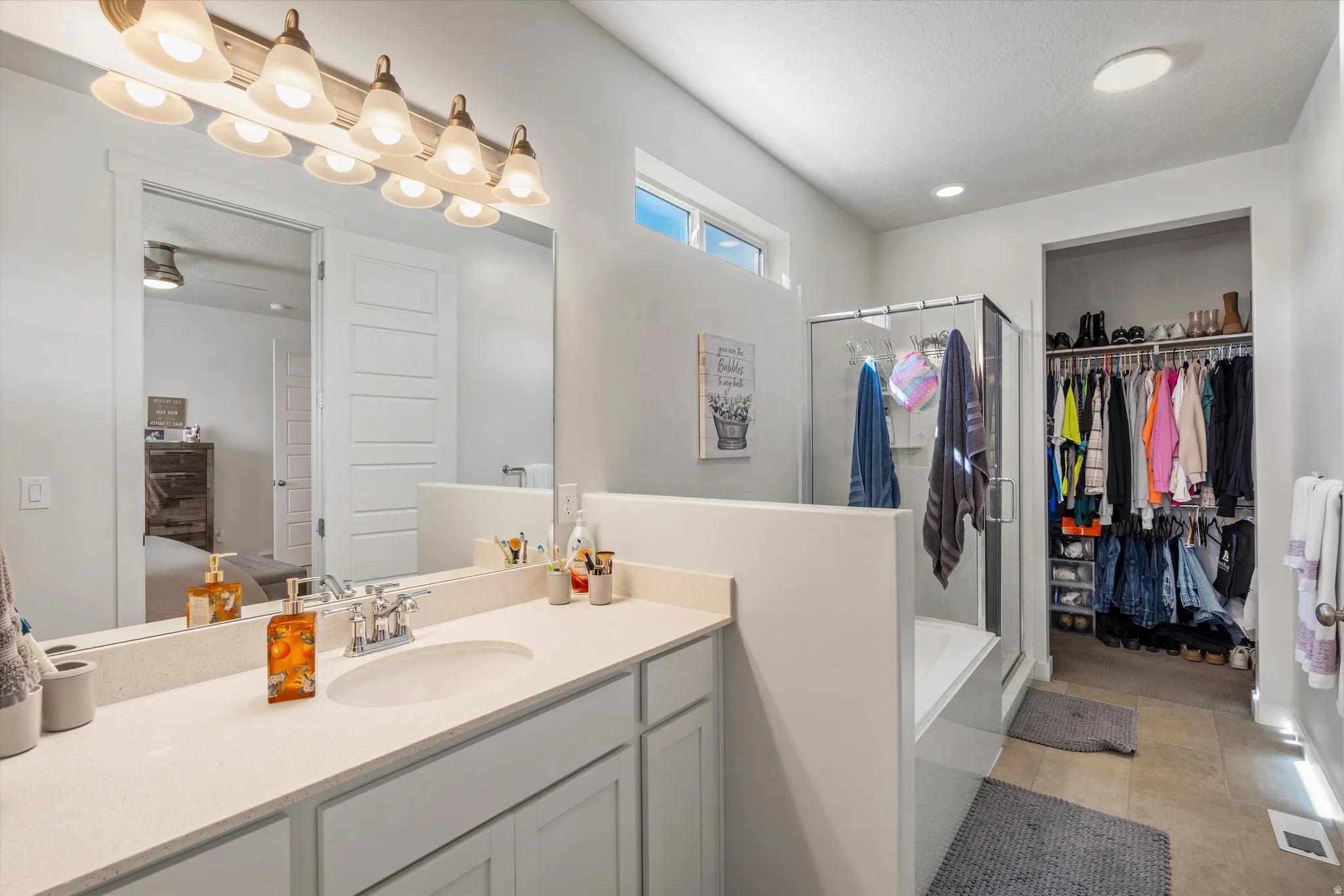 Bathroom with a shower stall, vanity, ensuite bathroom, and a walk in closet