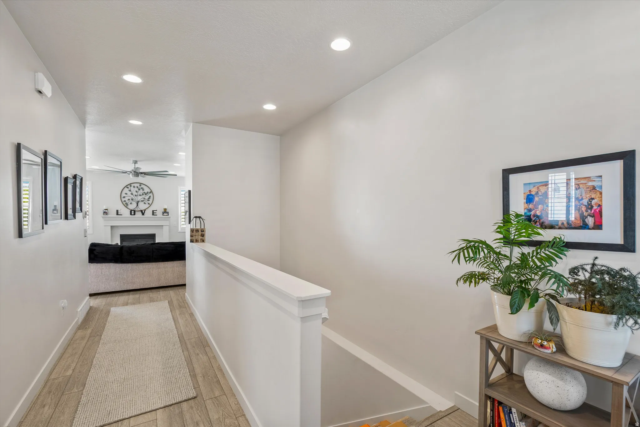 Corridor featuring wood tiled floors, an upstairs landing, and recessed lighting