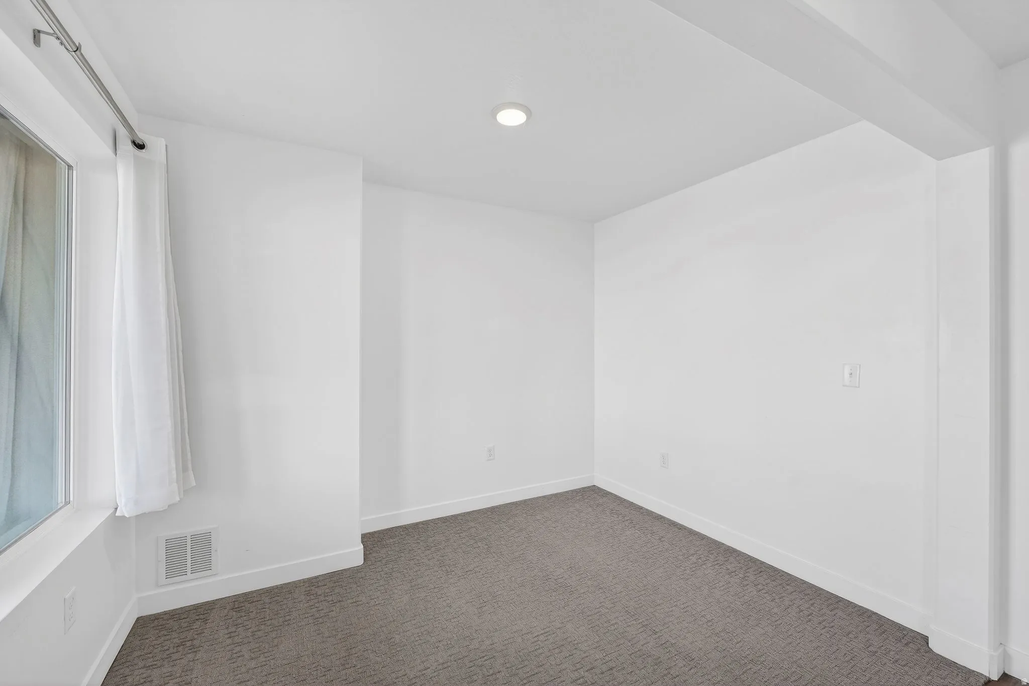 Unfurnished room with baseboards and dark carpet