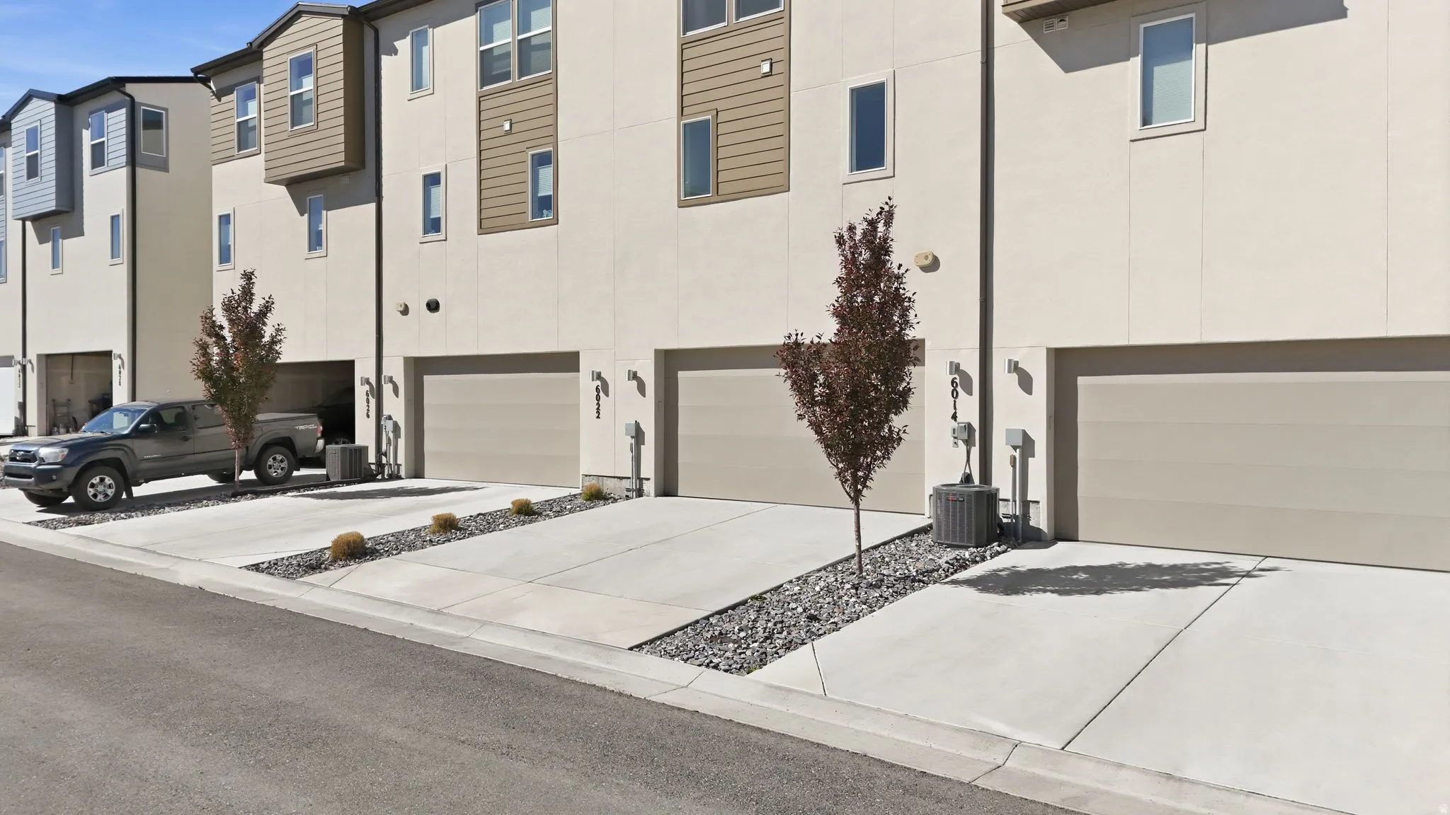View of front of house featuring an attached garage, stucco siding, and driveway