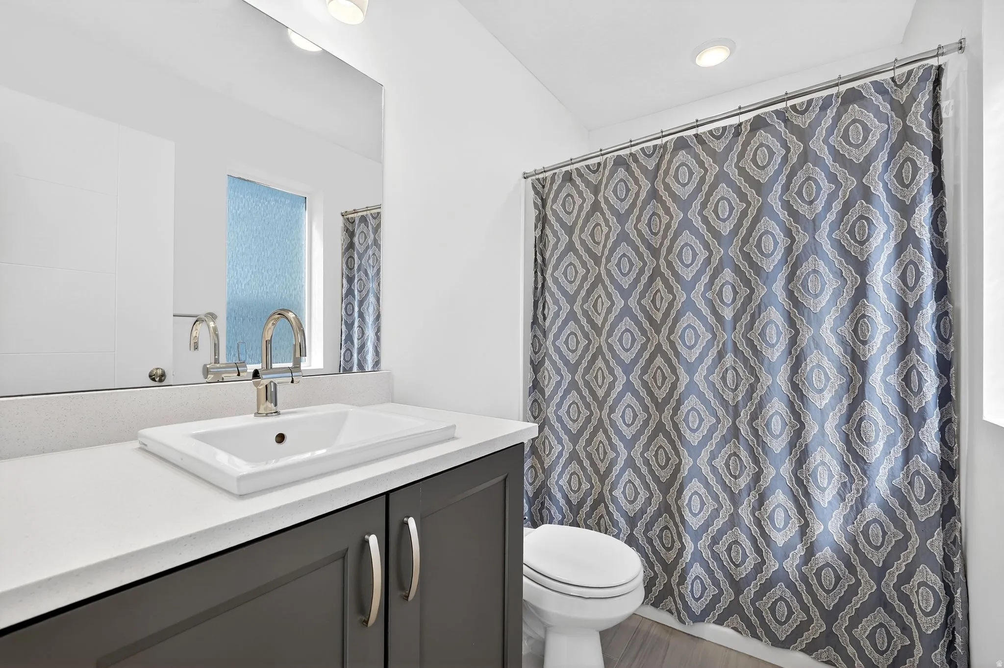 Full bathroom featuring vanity, a shower with curtain, and recessed lighting