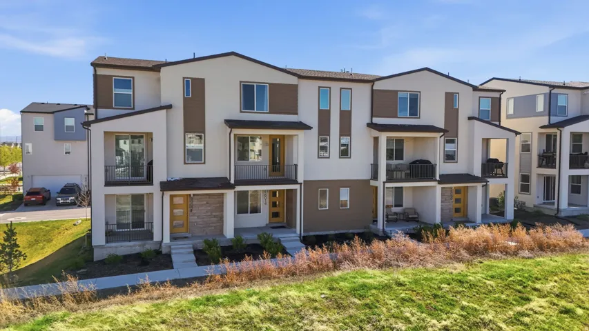 View of front of house featuring a balcony, a residential view, stucco siding, and stone siding